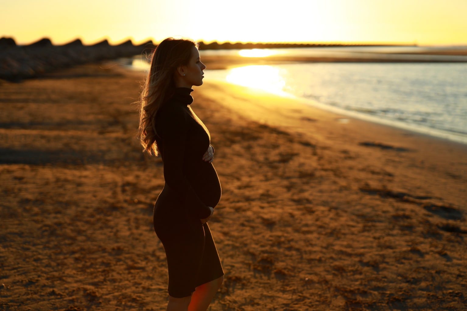 Pregnant woman on the beach doing yoga. Pregnant woman doing